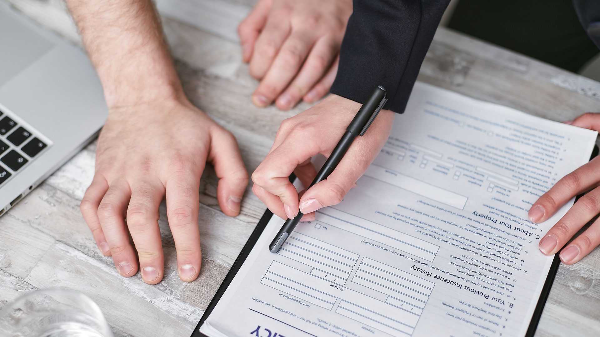 Hands filling in a form at a desk