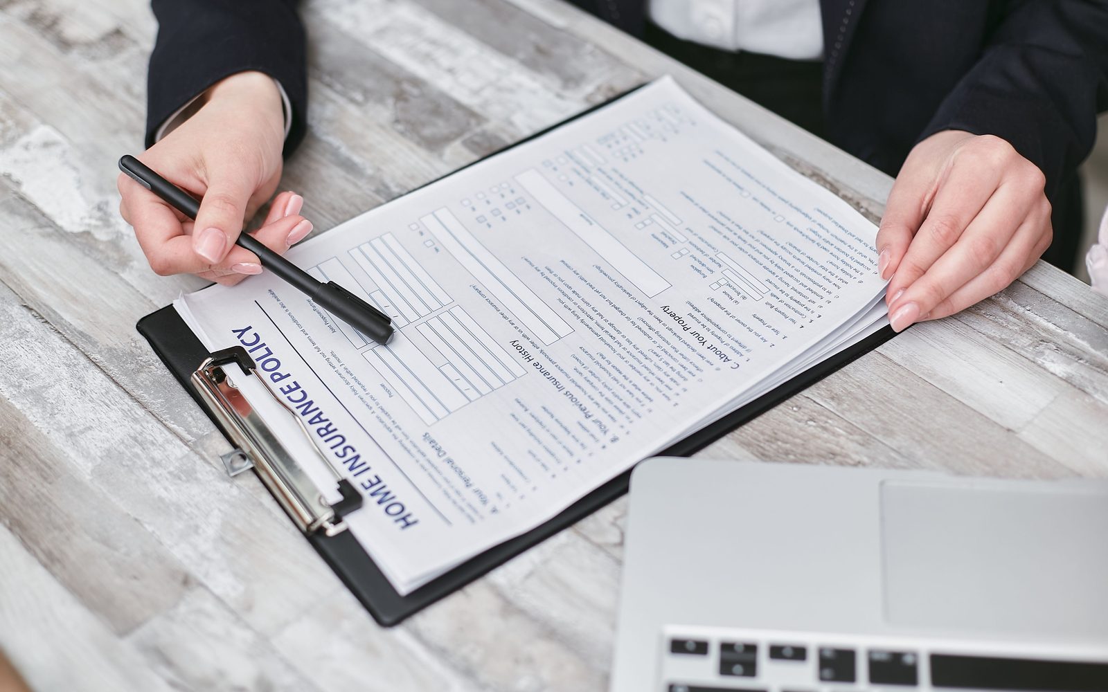 Hands holding a clipboard with an insurance form